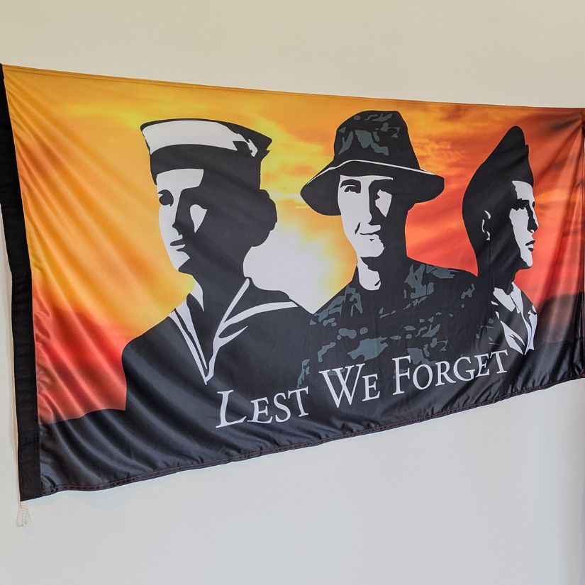 Military tribute flag with Lest We Forget text