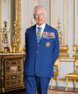 Elderly man in blue suit with medals indoors