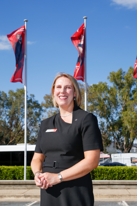 Smiling professional woman standing outdoors with flags
