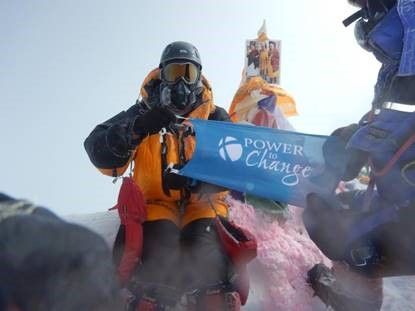 Climbers holding Power to Change banner on snowy peak