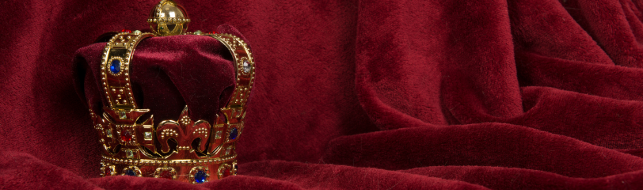 Golden jeweled crown on red velvet fabric