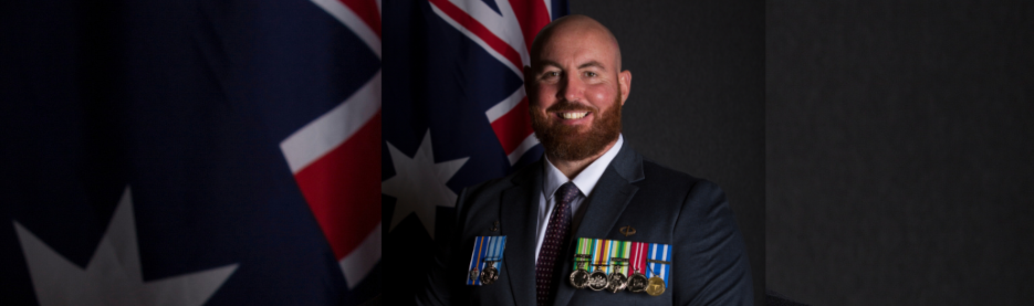 Smiling military officer with Australian flags