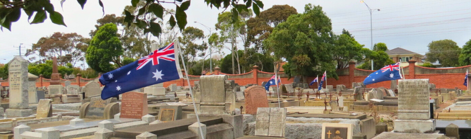 Australian flags in cemetery with gravestones