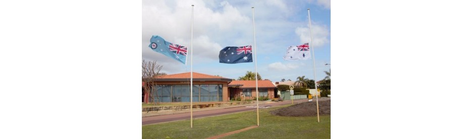 Australian flags flying at half mast outside building