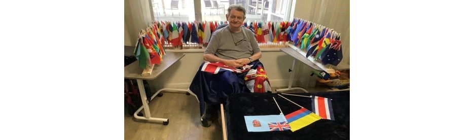 Man sitting with a collection of world flags